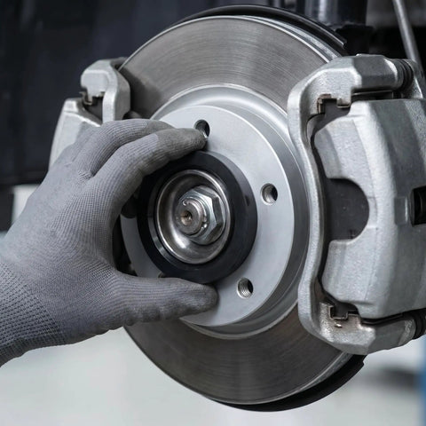 Hand installing 4 Pack Black Hub Centric Rings 60.1 To 73.1 Mm Wheel Centerbore Fillers on a brake system.