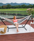 Woman lounging in Outdoor Double Hammock With Sturdy Steel Stand Heavy Duty Frame Holds Up To 450 Lb on patio deck with view