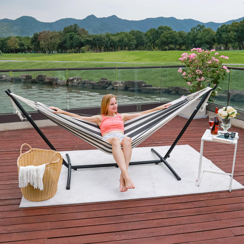Woman lounging in Outdoor Double Hammock With Sturdy Steel Stand Heavy Duty Frame Holds Up To 450 Lb on patio deck with view