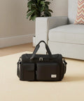 Black Sports Duffel Bag With Shoe Compartment And Wet Dry Separated Pocket on beige carpet next to sofa