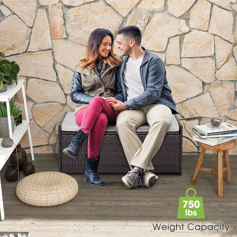 Couple seated on Outdoor 34 Gallon Storage Bench With Seat Cushion And Waterproof Liner, Wicker Brown Deck Box on patio.