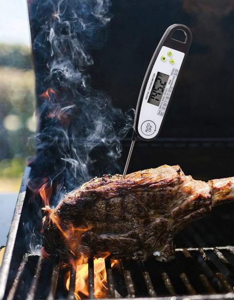 Digital Meat Thermometer For Grilling With Backlit Display, Instant Read In 2 To 4 Seconds, inserted in steak on grill.
