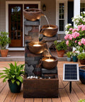 Five Tier Solar Outdoor Water Fountain With LED Lights 33 Point 5 Inch Tall Waterfall For Patio Or Backyard Easy Setup Solar Pump And Panel Included Decorative Pebbles Yard Vibe on a wooden deck with plants