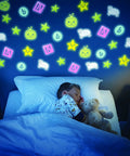 Glowing wall with Glow In The Dark Kids Sticker Pack featuring stars, sheep, and robot shapes above a sleeping child.