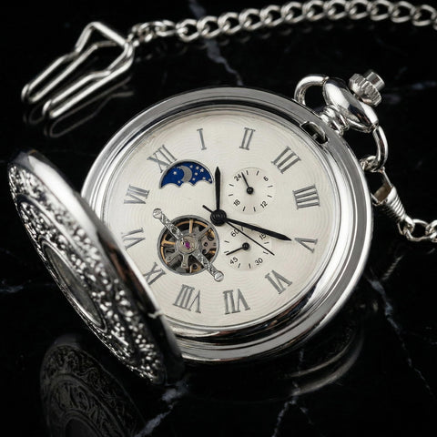 Vintage Mechanical Pocket Watch With Double Sided Floral Engraving Case Hunter Skeleton Design on display on black background.