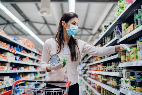 Woman shopping wearing disposable 3 ply face masks pack of 50 breathable ear loop masks in blue for all day comfort