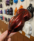 Molten Merlot Professional Car Paint Basecoat Full Gallon Volume sample displayed against a wall of paint samples.