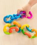 Plip Links Silicone Building Toys For Open Ended Creative Play A Fun Construction Set For Kids Aged 3 To 12 That Sparks STEM Skills Through Pattern Building And Preschooler Hands On Imagination, colorful silicone chain pieces on wood