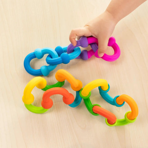 Plip Links Silicone Building Toys For Open Ended Creative Play A Fun Construction Set For Kids Aged 3 To 12 That Sparks STEM Skills Through Pattern Building And Preschooler Hands On Imagination, colorful silicone chain pieces on wood