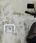Heavy Duty White Iron EV Charging Station Rain Cover Wall Mount Waterproof Outlet Box for electric bike near textured wall.