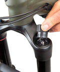 Hand using FR-5.2 Bicycle Cassette Lockring Tool With 12-Spline Design on bike fork, 23.5mm diameter, alloy steel, Shimano compatible.