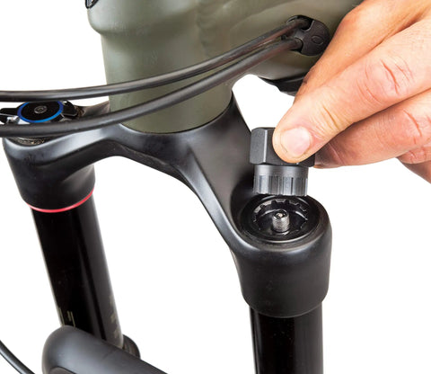 Hand using FR-5.2 Bicycle Cassette Lockring Tool With 12-Spline Design on bike fork, 23.5mm diameter, alloy steel, Shimano compatible.
