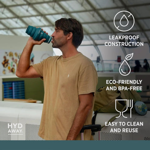 Man drinking from 25oz Collapsible Travel Water Bottle With Leakproof Flip Top Lid BPA Free while standing in an airport.