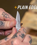 Close-up of hand holding Paraframe Mini Pocket Knife EDC Folding Knife 2.2 Inch Fine Edge Stainless Steel carving wood piece