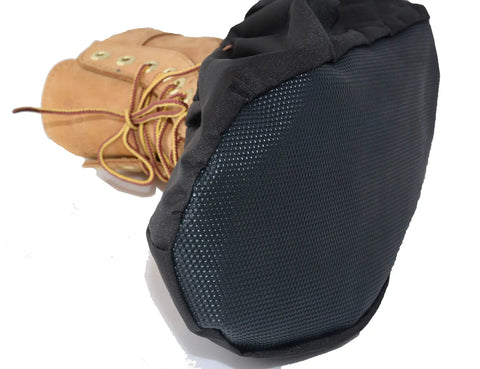 Close-up of black non-slip sole on two pairs non slip waterproof reusable shoe covers for contractors and carpet floor protection.