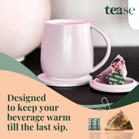 Self Heating Mug With Phone Controlled Heat Settings And Wireless Charging Stand To Keep Your Morning Brew Piping Hot All Day Long Sip At Your Pace While This Rechargeable Tech Build Keeps Every Drop Cozy And Fresh in soft pink color with tea bag.