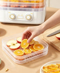 Big Time 6 Tray Food Dehydrator For Home With Clear Racks And Digital Temperature Timer Controls To Knock Out Homemade Jerky Dried Fruit Veggies And Dog Treats Quick As Can Be being used to prepare orange and apple slices.