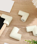 White Foam Corner Protectors 12-Piece U-Shaped Edge Guards for Furniture and Photo Frames on wood surface