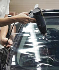 Person using heat gun from 9 In 1 Vinyl Wrap Tools Kit With Heat Gun For Car Wrapping And Window Tinting Includes Squeegees, Wrapping Knives