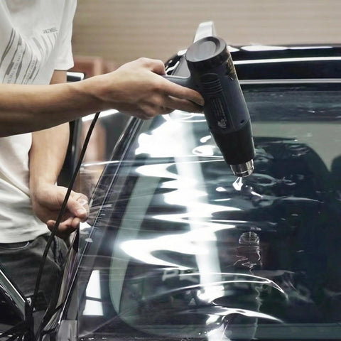 Person using heat gun from 9 In 1 Vinyl Wrap Tools Kit With Heat Gun For Car Wrapping And Window Tinting Includes Squeegees, Wrapping Knives