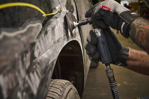 Compact Right Angle Pneumatic Die Grinder With 1/4 Inch Collet And 20000 Rpm Motor used for grinding on a car surface in an auto shop.