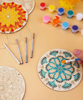 DIY Mandala Wind Chimes Craft Kit for Kids Color Your Own Wind Chimes With Wood Hanging Ornaments 24 Sets Kid Friendly Fun Craft Project For Home School Party Activity showing painting process with brushes and colors.