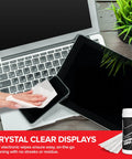 Top-down view of electronic screen cleaner wipes bottle with white cap on desk beside laptop and tablet