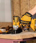 Person using 20V Cordless Brushless Impact Driver Set With 1/4 Inch Drive on wood; includes dual batteries and carry bag.