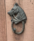 Handcrafted Cast Iron Horsehead Wall Hook With A Knockout Rustic Coffee Bean Brown Finish Built Like A Tank For Hanging Coats Keys Hats And Gear Includes Hardware on wooden surface.