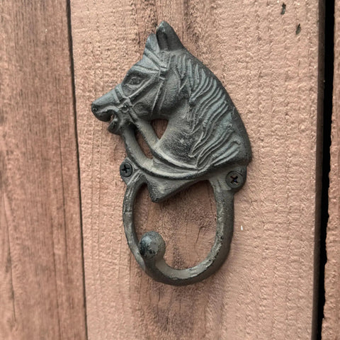 Handcrafted Cast Iron Horsehead Wall Hook With A Knockout Rustic Coffee Bean Brown Finish Built Like A Tank For Hanging Coats Keys Hats And Gear Includes Hardware on wooden surface.