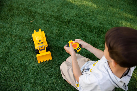 Kid playing with Kid Friendly RC Loader Truck With Easy To Use Controller, 10.5 Inch Construction Vehicle, on grass