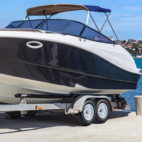 Boat on a trailer with a Trailer Tire And Wheel Set With ST175/80D13 Tire On 13 Inch Rims, 5 Lug On 4.5 Inch Bolt Pattern, Load Range C, 6PR, 50 Psi Max, White 13x5 Wheels, Set Of 2 near water.