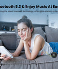 Woman using a smartphone on a couch next to Pocket Bluetooth Speaker With Big Bass, 5W Portable Wireless Speaker, IPX7 Waterproof, 8 Hours Playtime.