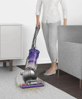 Person using Ball Animal Origin Upright Vacuum For Pet Hair And Allergies, Pro Grade Suction With Ball Steering in purple on carpet