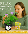 Woman interacting with Touch Me Plant Seeds Indoor 2 Pack That Close Leaves When Touched beside product packaging on a table.
