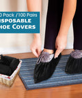 Person wearing 200 Pack Disposable Shoe Covers Non Slip Waterproof Non Woven Fabric Black Booties For Indoor Outdoor Use Extra Large 100 Pairs