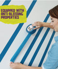 Woman applying Blue Painters Tape 2 Inch Wide Pack Of 24 Residue Free UV Resistant Masking Tape For Sharp Clean Lines On Walls