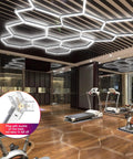 Hexagon LED Garage Light Fixture Pack 24 Count High Output 192W 23040LM 6500K Super Bright Grid System For Warehouse Workshop Basement Gym Car Detailing installed on ceiling in a gym.