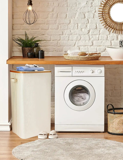 100L Collapsible Laundry Basket With Lid Waterproof Oxford Fabric Bamboo Frame placed beside a washing machine
