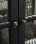 Close-up of black wood grain lattice doors with brass knobs on a 30 Inch Glass Curio Display Cabinet With LED Lighting