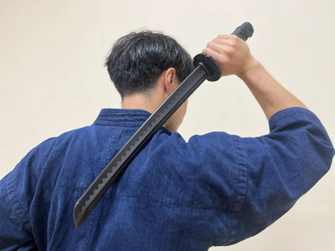 Person holding Polypropylene Short Katana Black Sword With Black Scabbard 23.5 Inch Overall Length 16 Inch Blade over shoulder