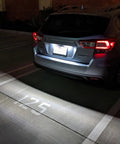 Car with OEM-Fit 3W Full LED License Plate Light Kit Direct Fit For Scion FR-S Toyota 86 Subaru BRZ Impreza WRX STI Legacy Crosstrek Ascent With 24-SMD Xenon White LEDs illuminating parking spot.