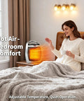 Woman enjoying warmth from Portable Space Heater 1500W 750W PTC Ceramic Fast Heating on bedside table, bedroom setting