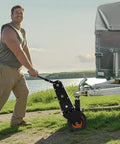Heavy Duty Trailer Dolly With 1000 Lb Tongue Weight Support swappable hitch balls, maneuvering a trailer by a lake.