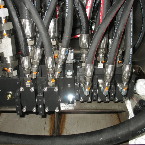 12-pack hydraulic hose fittings with 3/8 in JIC 37° female ends mounted on a metal manifold with black hoses