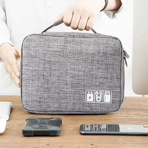 Hella Organized Travel Case For Small Electronics And Usb Charging Gear Including Phone Cables Mouse Sd Cards Power Bank Earphone Bag held by hand on a desk.