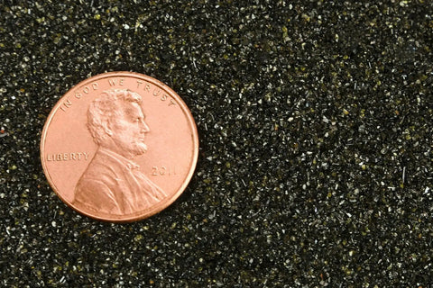Extra Fine 30 To 60 Mesh Abrasive Blast Media For Sandblasting Cabinets 50 Lb Box Fast Cutting With Low Silica Less Than 0.1 Percent Ideal For Removing Paint And Rust From Steel And Structural Metal next to a penny for scale