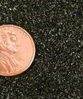 A penny placed on Extra Fine Abrasive Blast Media 30/60 Mesh For Sandblast Cabinets 75 LB Bag Ideal For Metal Prep Surface Finishing Rust Removal Deburring And Smooth Consistent Finish. Image shows size comparison.