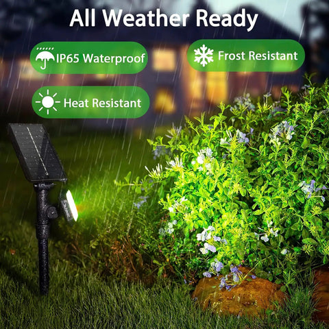 4 Pack Solar Spotlight Lights Outdoor Waterproof Landscape Lighting illuminating garden bushes in rain, showcasing weather resistance.