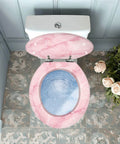 Toilet Seat Round Resin for Bathroom in pink marble design with blue water effect, fitted on toilet bowl from above view.